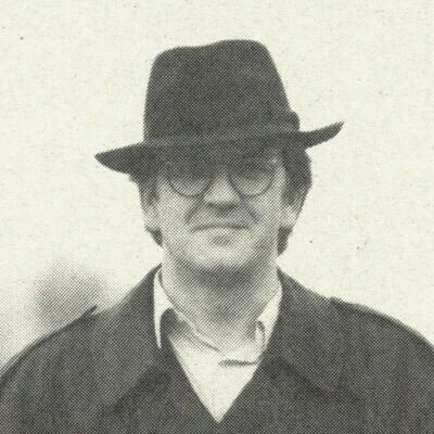 Ein Mann mit Hut der entschlossen hart und direkt in die Kamera schaut.