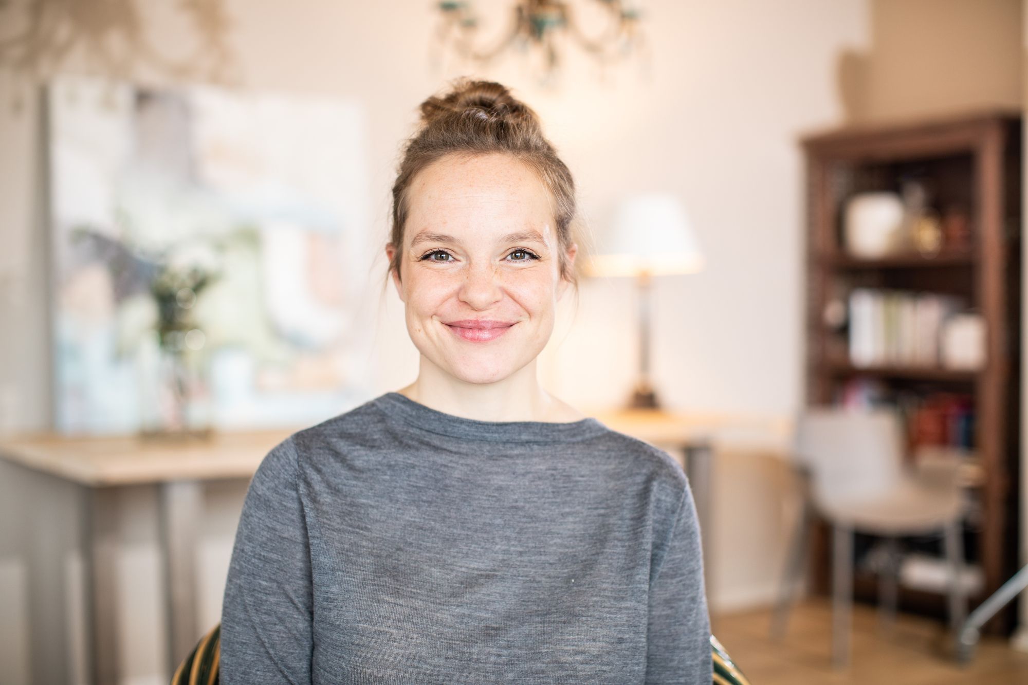 Porträt der Autorin Natalie Stüben, eine Frau mittleren Alters mit hochgestecken Haaren in einer heimeligen Umgebung.