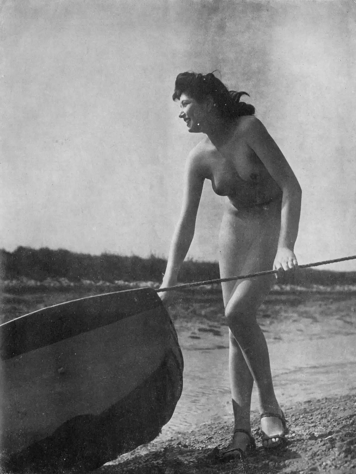 Eine nackte Frau landet ein Boot an. Hauptaugenmerk des Bildes ist die Beckengegend des Bildes. Hier sinde keine Deatils mehr erkennbar, sämtliche Details sind retuschiert.