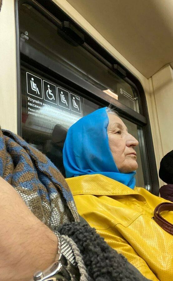 Eine Frau in der Moskauer U-Bahn trägt die Farben der ukrainischen Flagge.