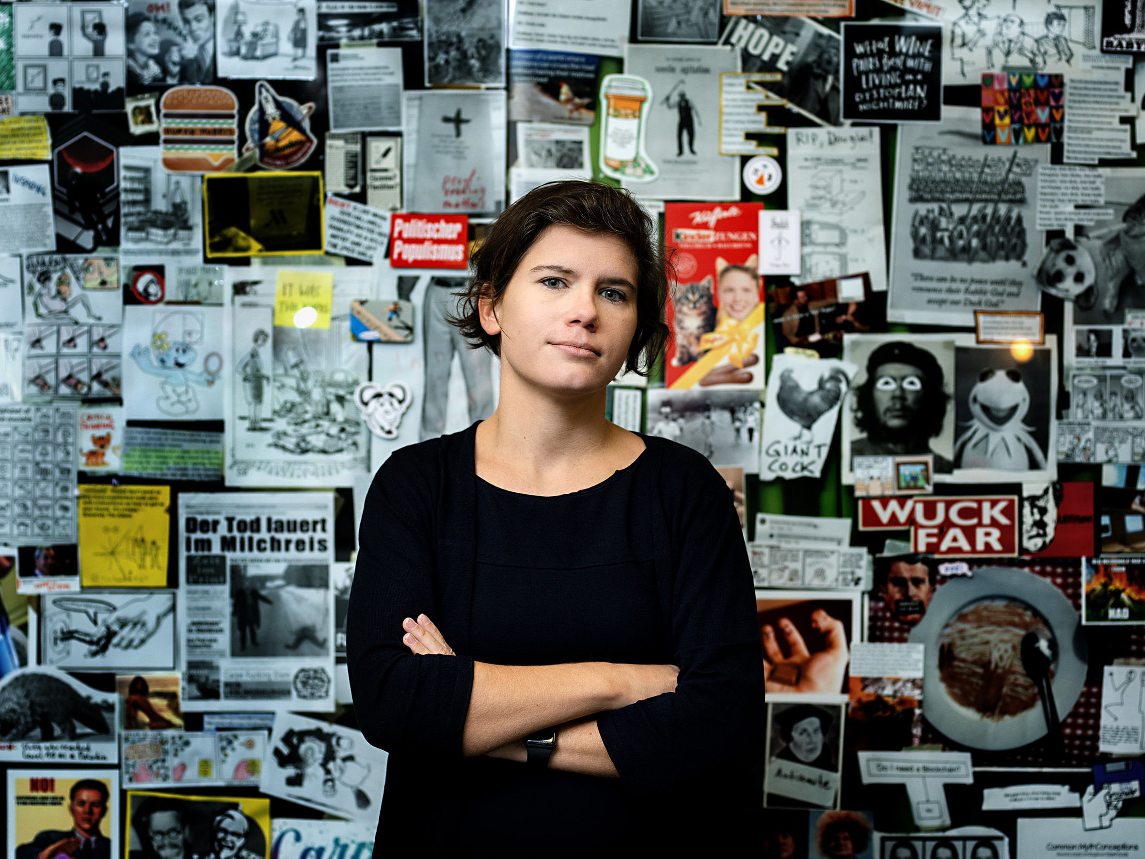 Ingrid Brodnig steht vor einer Wand mit Zeitungsausschnitten.