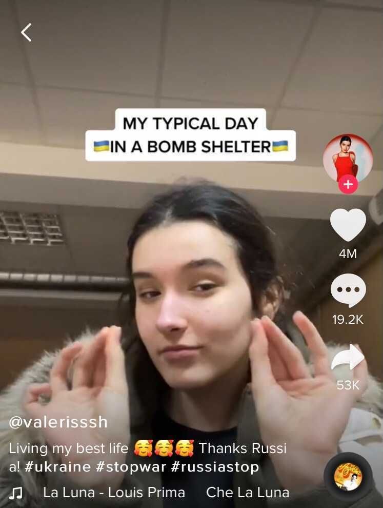 Eine junge Frau macht in einem Video einen Wiitz, aus dem Bombenkeller heraus. in dem sie sich vor den Bomben schützt. Es ist ein Screenshot..