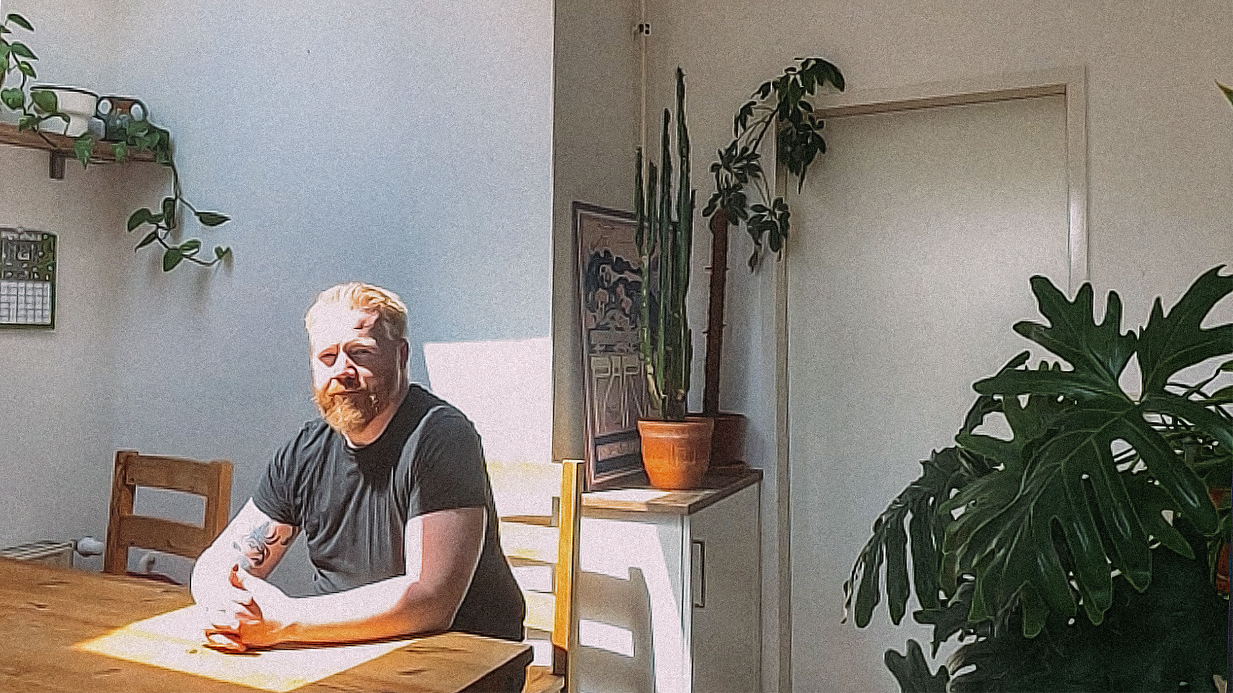 Martin sitzt an einem Tisch, Licht fällt durch ein Deckenfenster auf seinen Kopf.