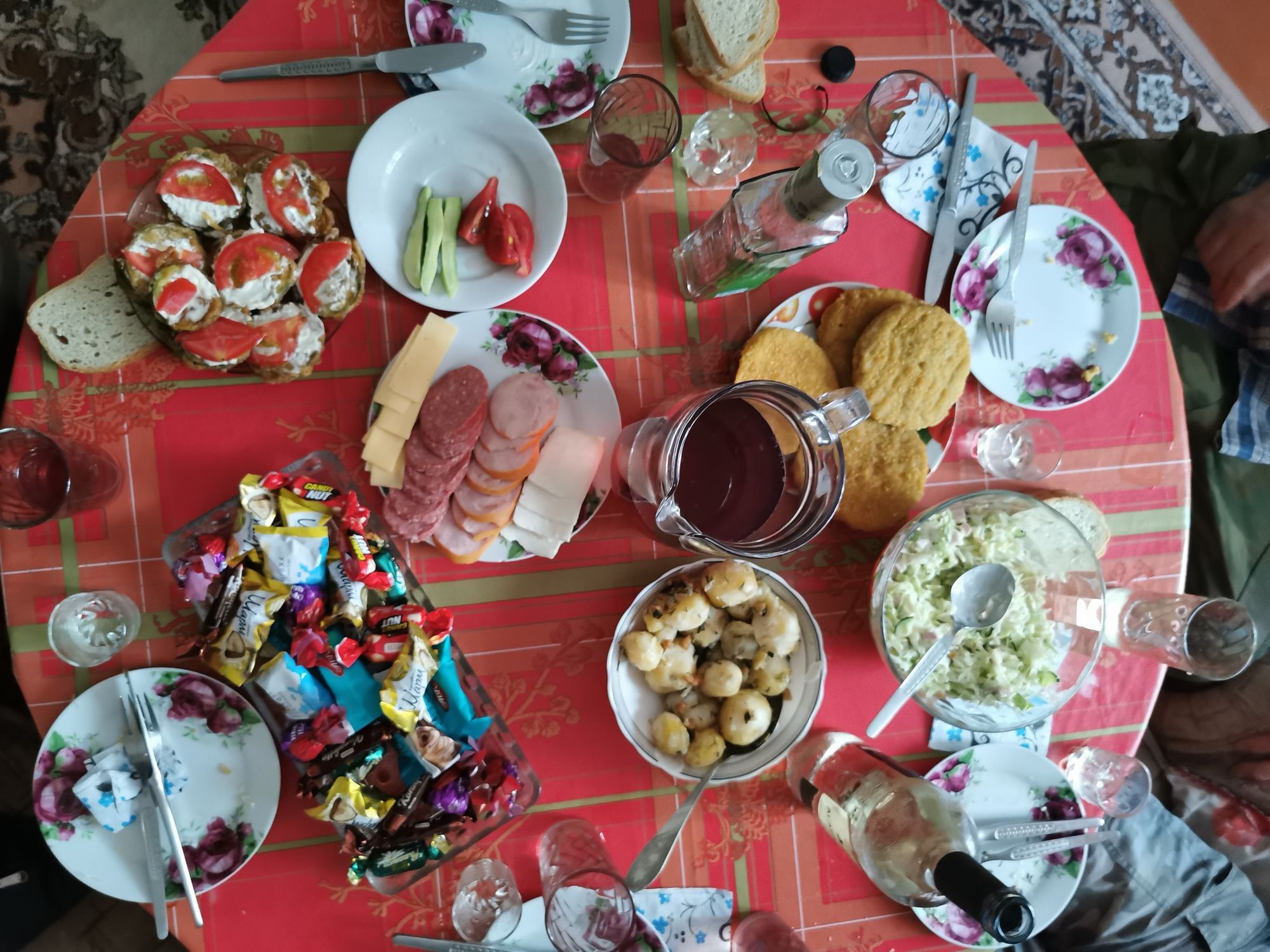 Draufsicht auf einen Tisch. Er ist gedeckt mit Wurst, Gemüse, Salat und Schnitzeln.