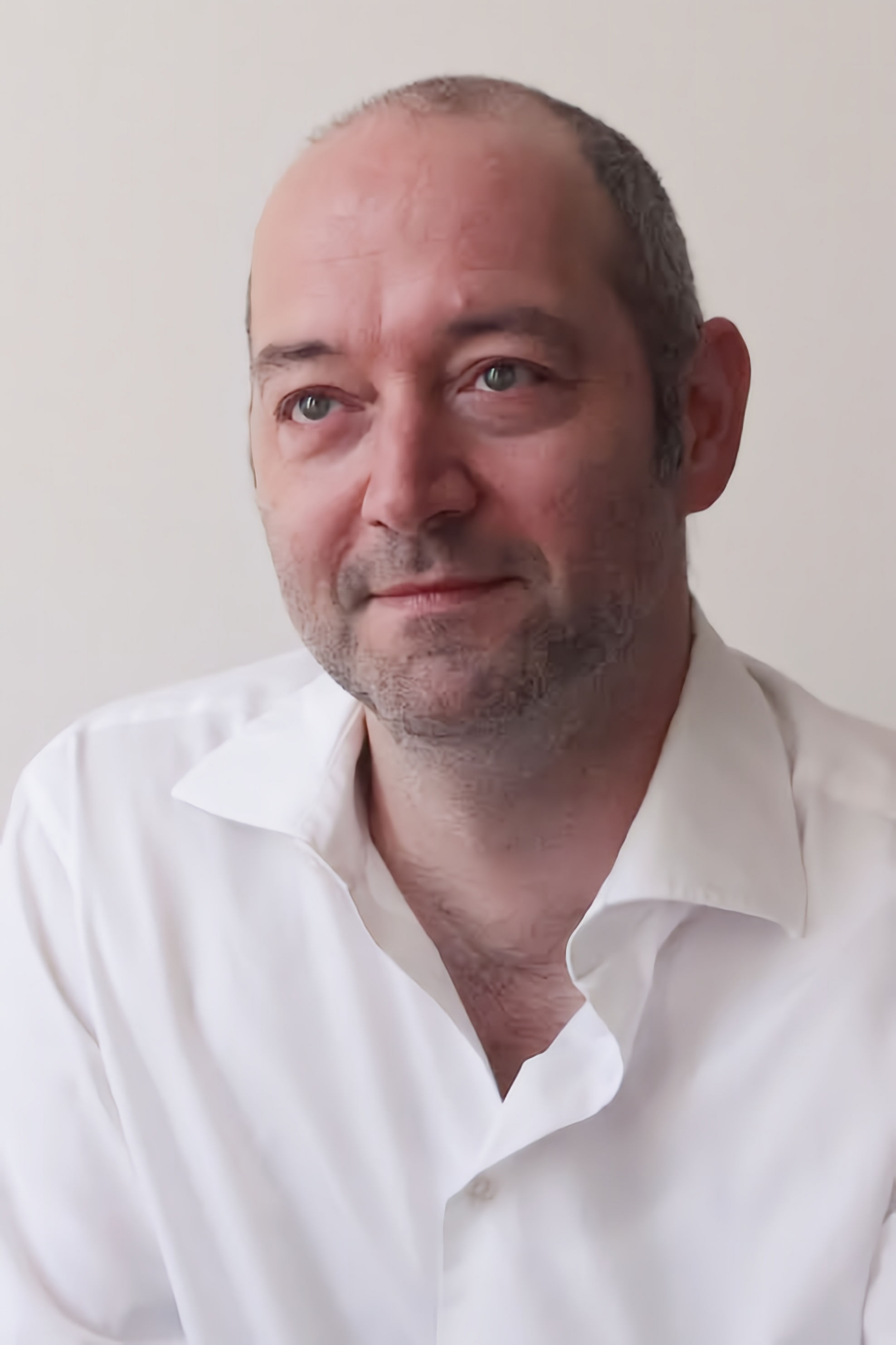 Wir sehen den Psychiater Schlimme, der mit weißem Hemd etwas in die Ferne sieht. Er hat eine Halbglatze.