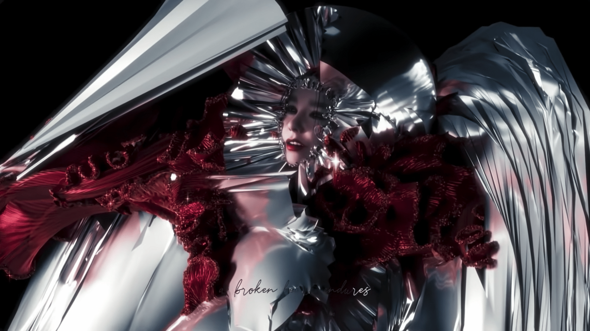 Man sieht auf dem Bild ein Still aus Björks Video Ovule, viel silber, viel rot, Bjrök verschwindet fast zwischen den graphischen Elementen.