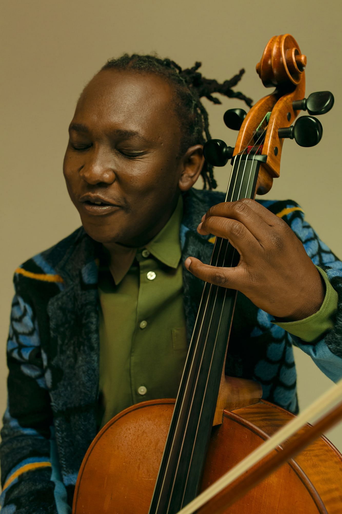 Man sieht einen Mann an einem Cello sitzen, der hat die Augen geschlossen.