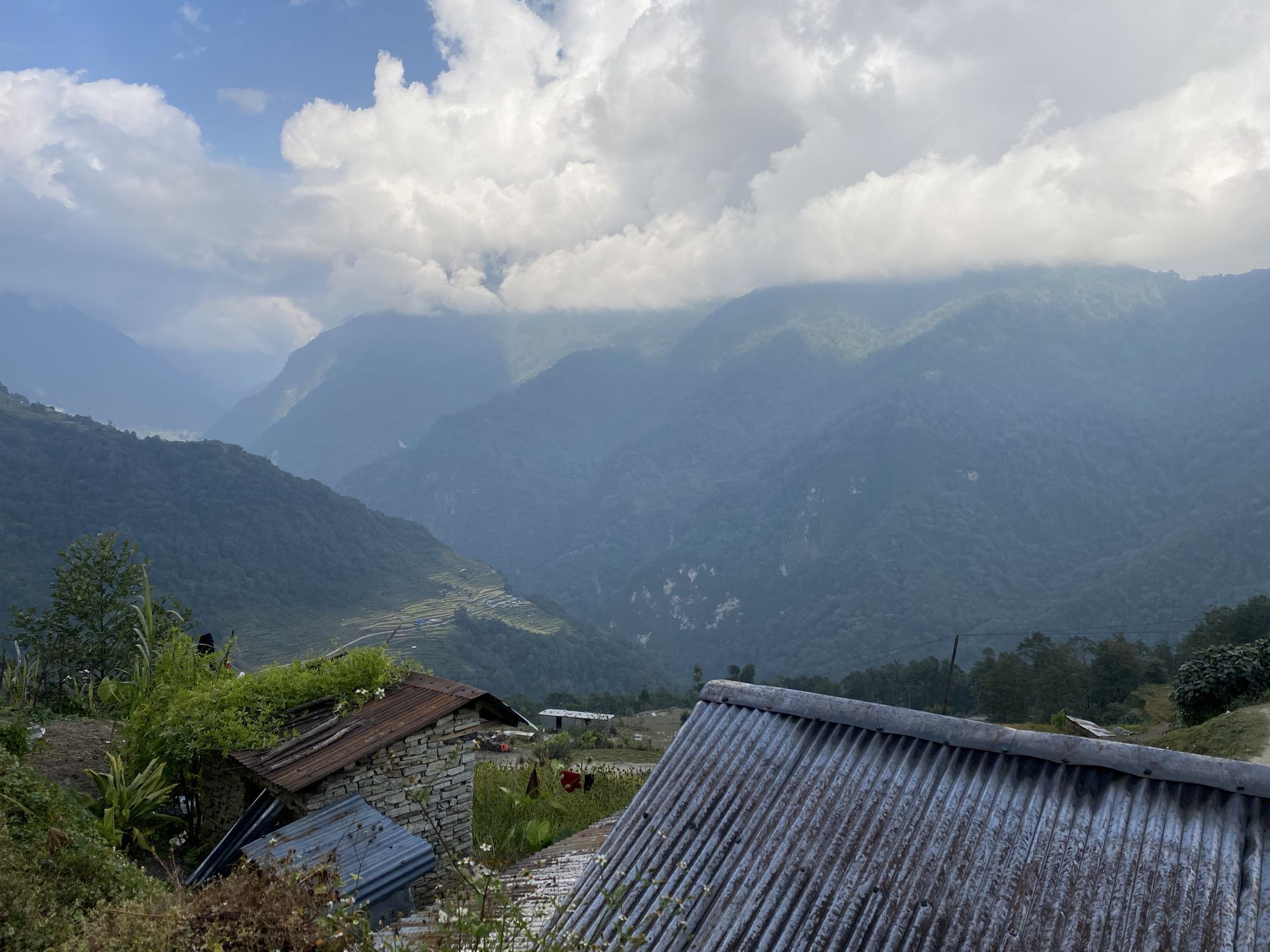 Eine Berglandschaft, im Vordergrund sind Hausdächer zu erkennen