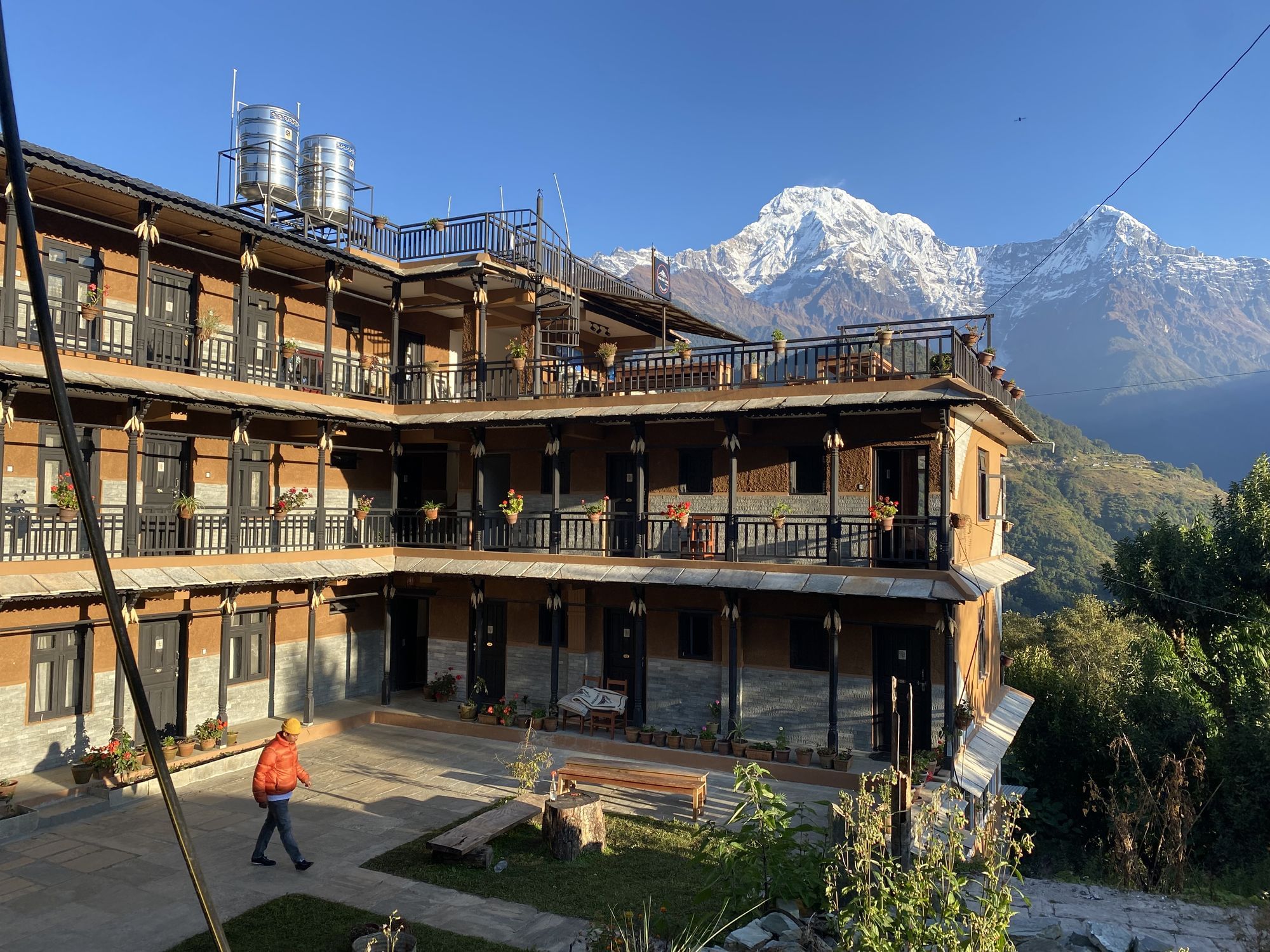 Ein Hotel in den Bergen. Ein Mann läuft über den Hof.
