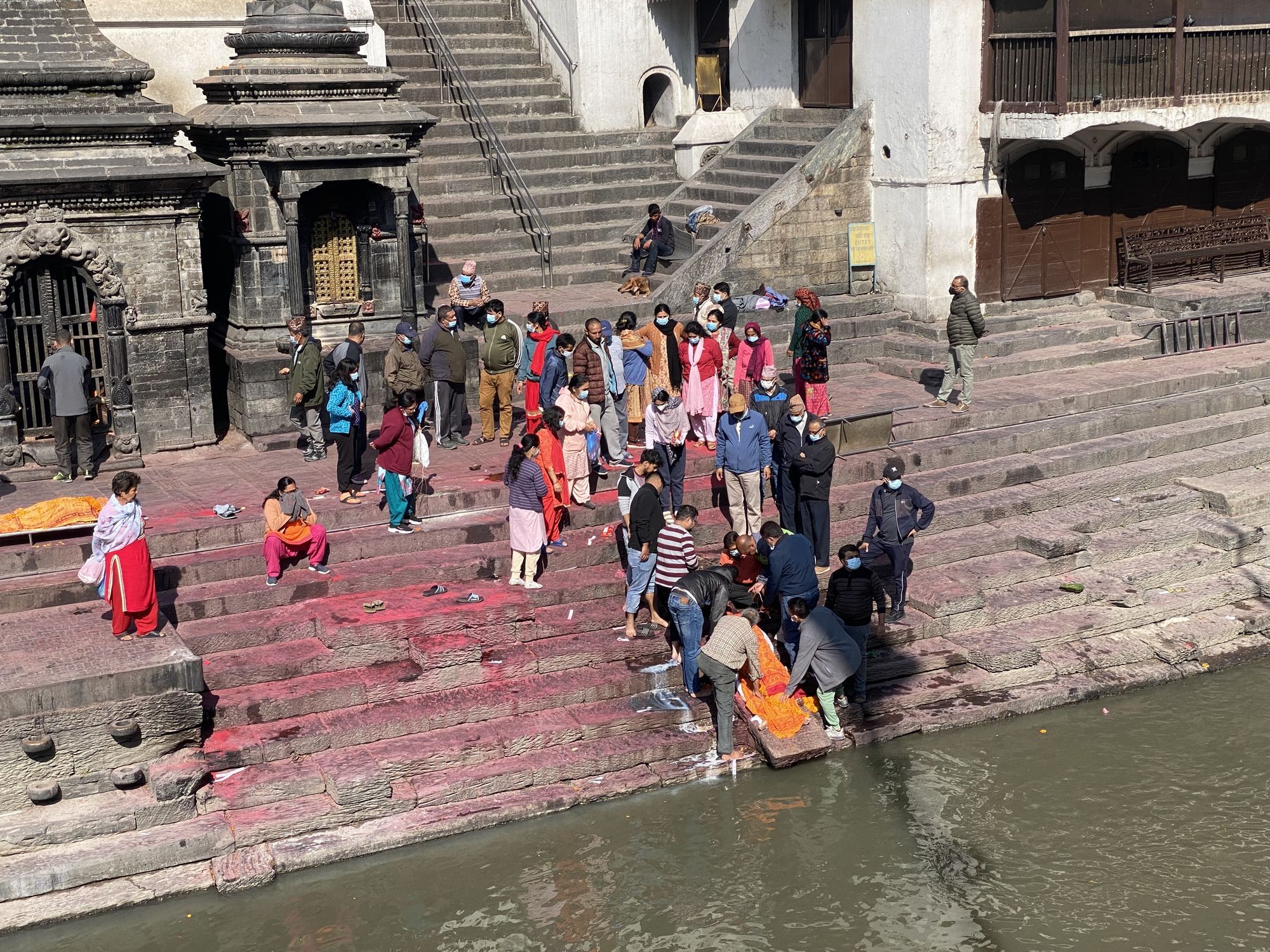 Bei einer Trauerfeier in Kathmandu umringen die Gäste einen Toten.