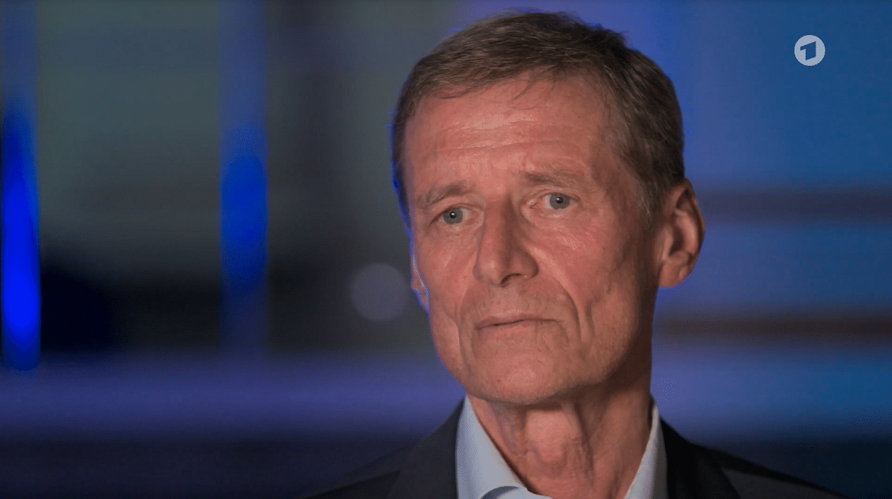 Wir sehen Ulrich Hegerl, einen älteren Mann, der in die Kamera schaut.