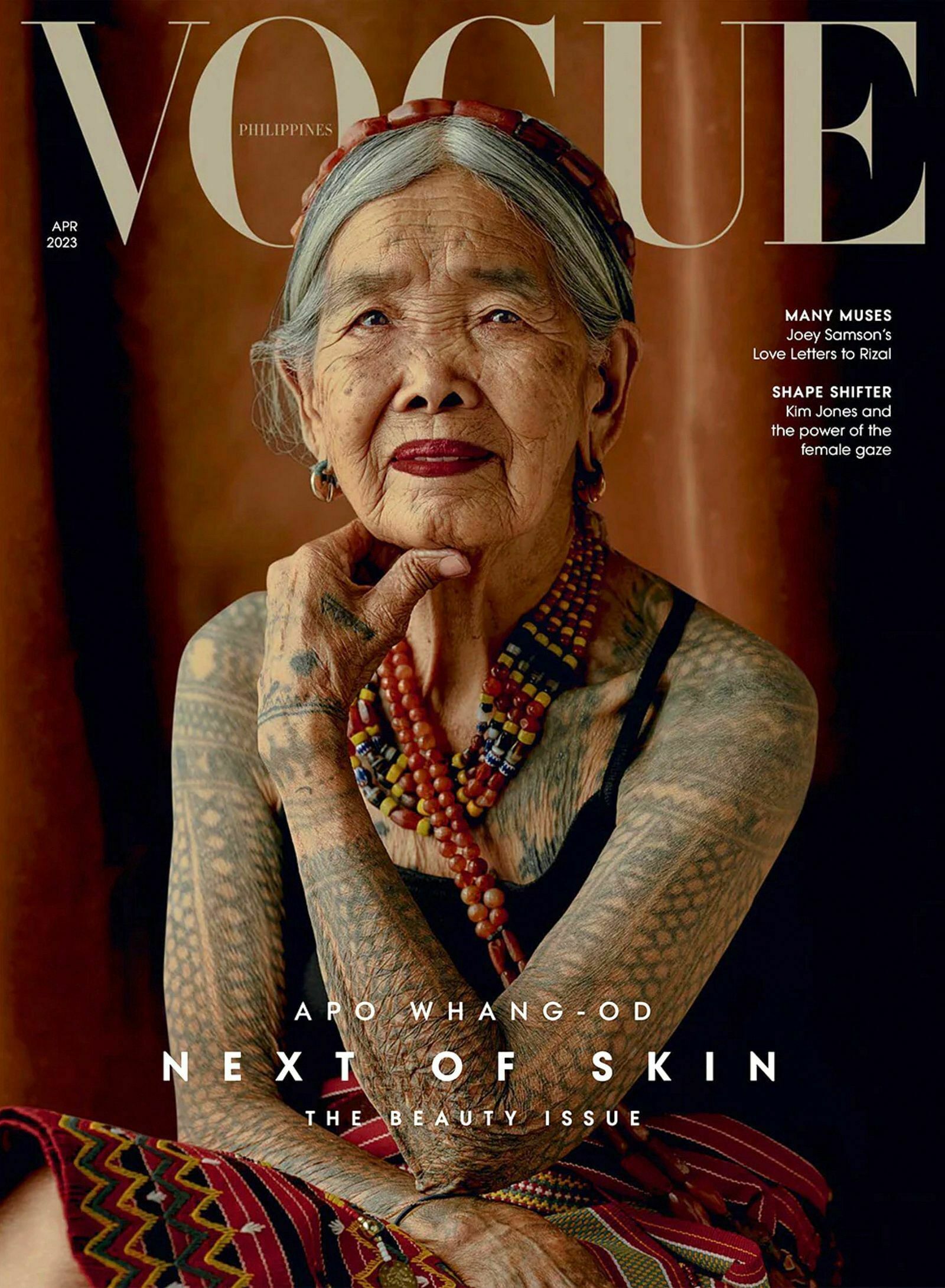 Man sieht das Cover des Magazins Vogue. Darauf ist eine ältere Dame zu sehen. Sie trägt ein Spaghetti-Trägertop und blickt idirekt in die Kamera, ihre Arme und ihr Brustkorb sind über und über mit Tattoos versehen.