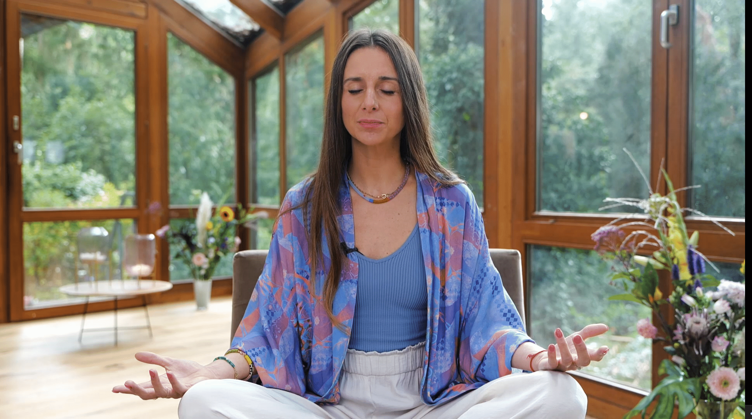 Wir sehen, wir Laura Malina Seiler im Schneidersitz mit geschlossenen Augen meditiert.