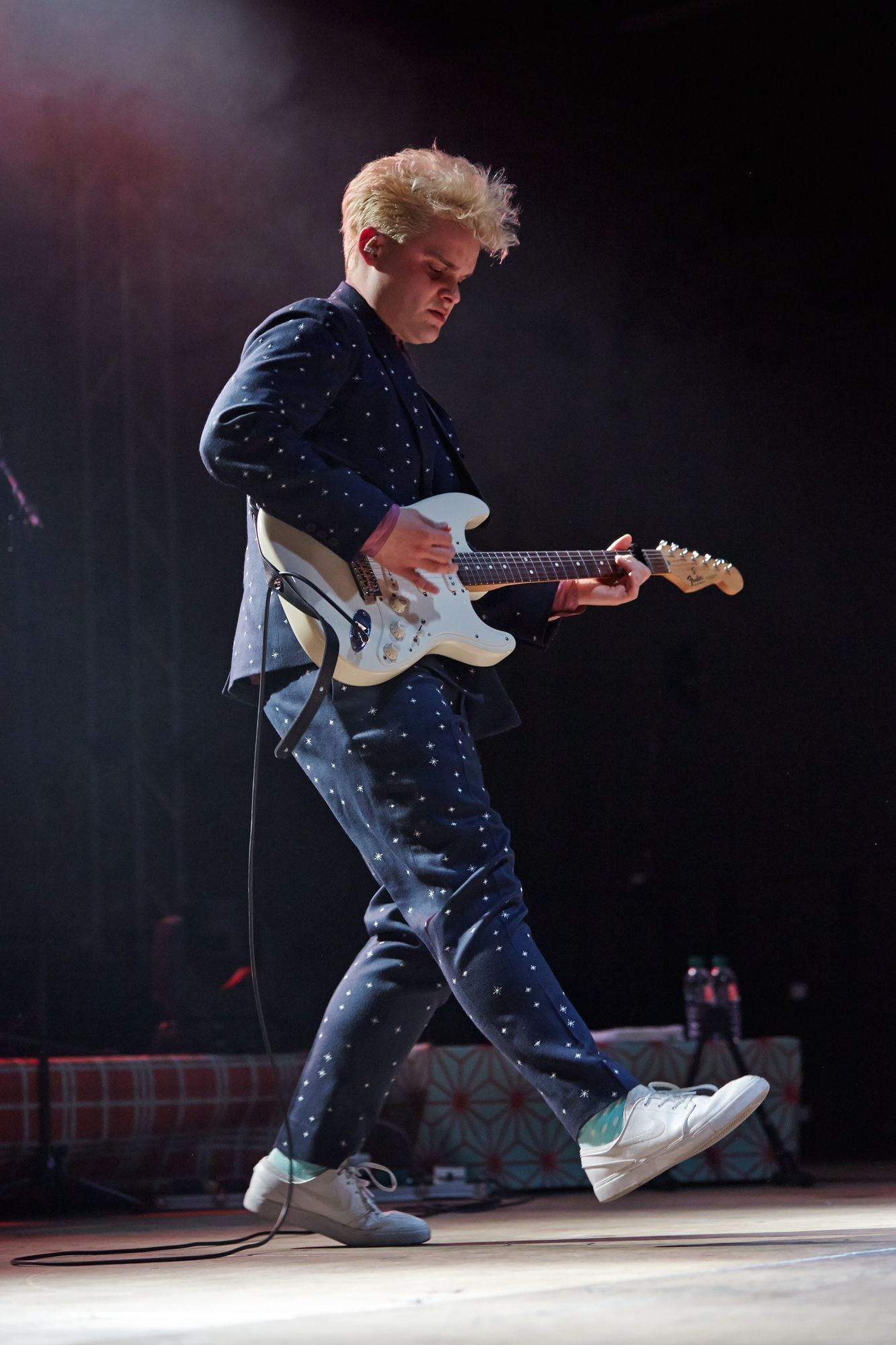 Man sieht Tristan Brusch, wie er auf der Bühne Gitarre spielt und dabei sehr konzentriert ist.