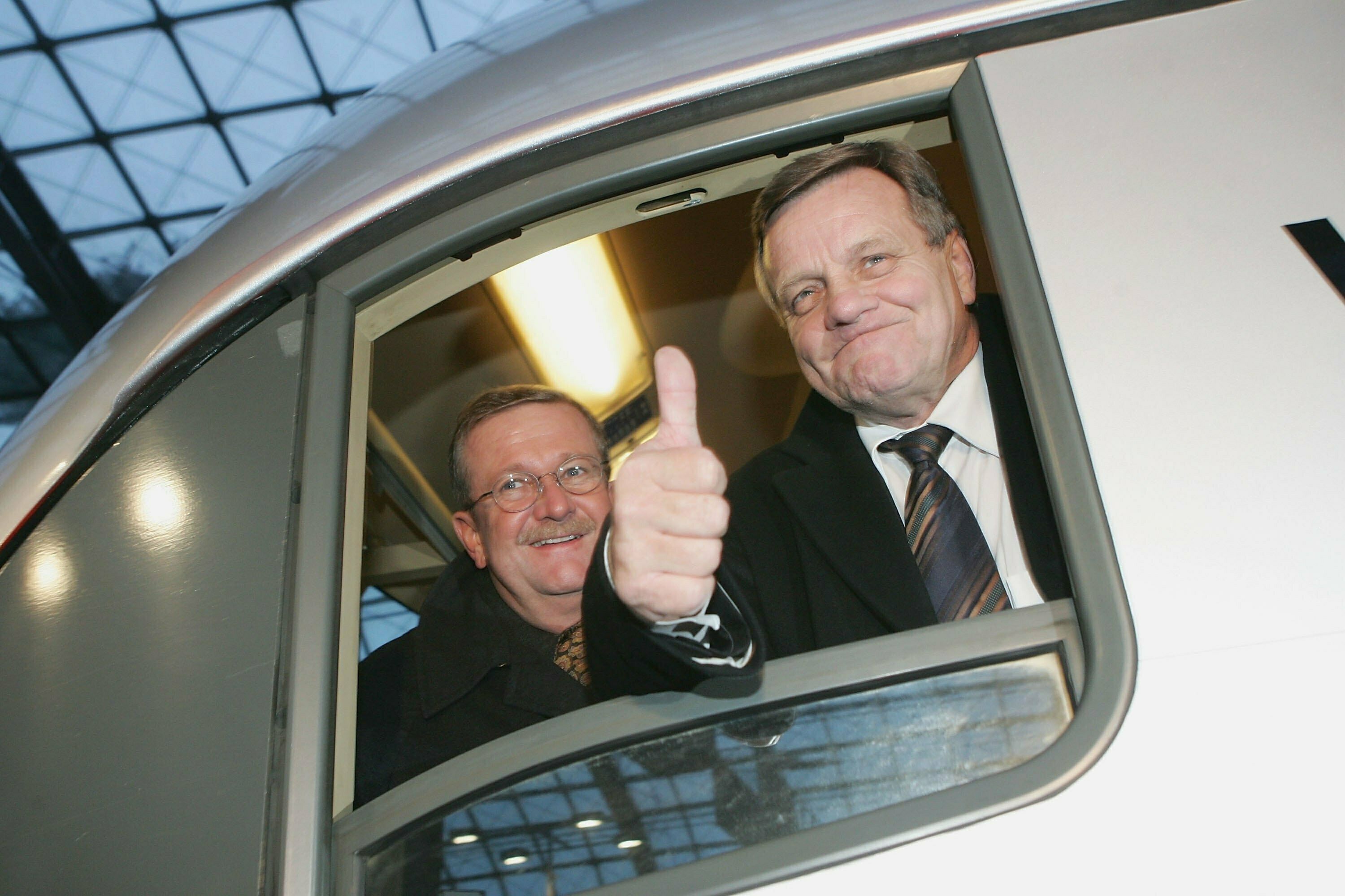 Wendelin Wiedeking Vorstandsvorsitzender des deutschen Sportwagenherstellers Porsche AG, und Deutsche Bahn-Chef Hartmut Mehdorn schauen aus dem Fenster einer neuen Lokomotive, die Porsche von der Deutschen Bahn am 3. Februar 2006 im Berliner Hauptbahnhof erhalten hat.