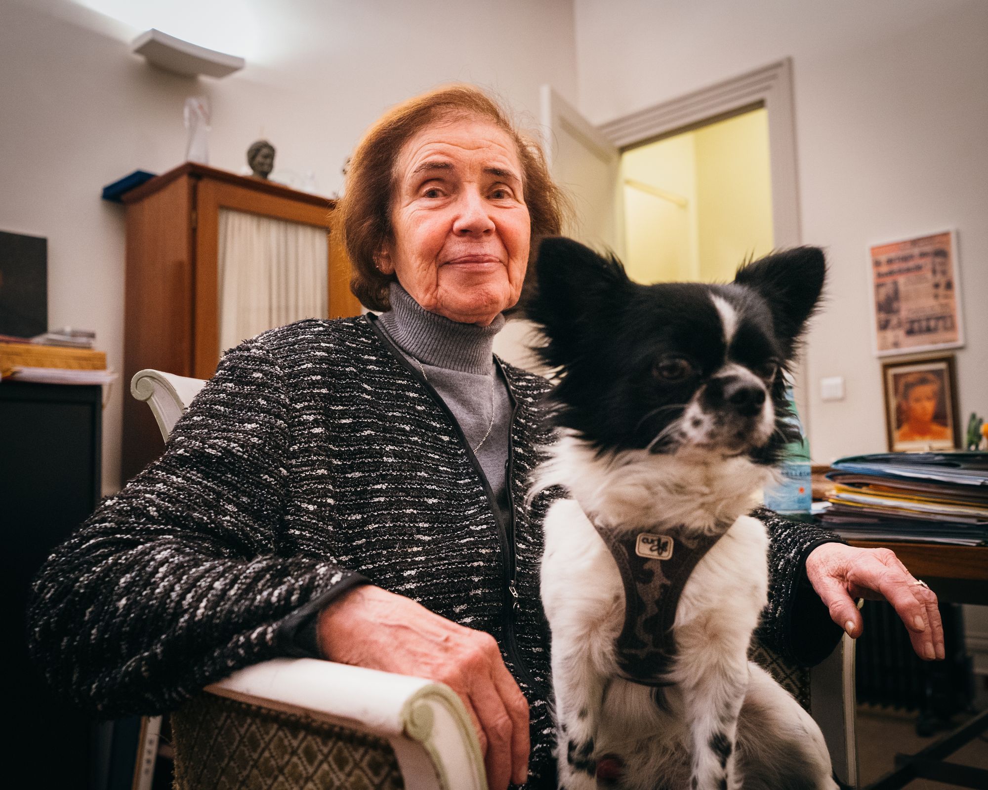 Beate Klarsfeld blickt in die Kamera. Sie sitzt auf einem Stuhl und trägt einen kleinen Hund auf dem Schoß.