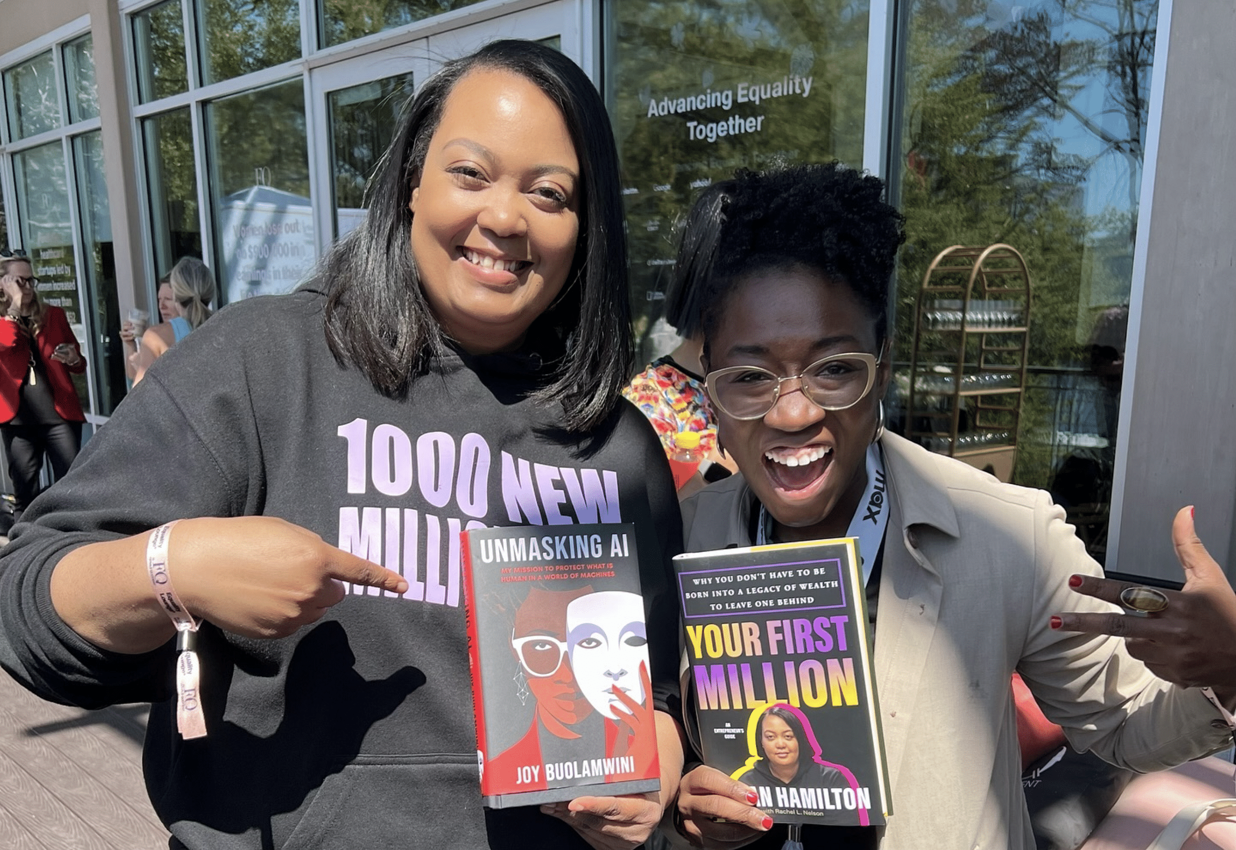 Arlan Hamilton und eine andere Autorin blicken in die Kamera und halten das Buch der jeweils anderen.
