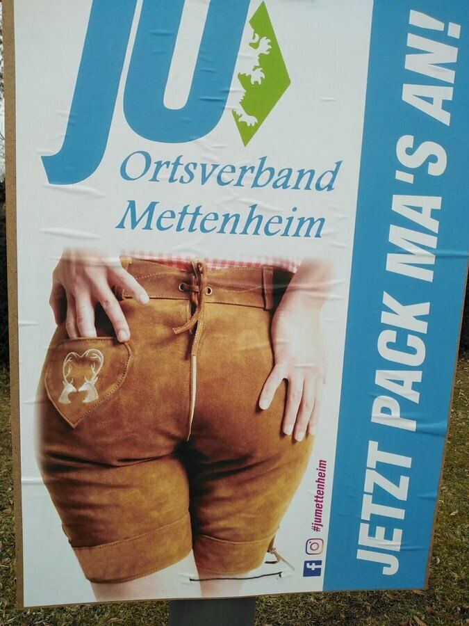 Auf dem Plakat ist ein Po einer Frau zu sehen, in einer Lederhose, ihre Hände liegen darauf. Daneben steht "Jetzt pack ma's".