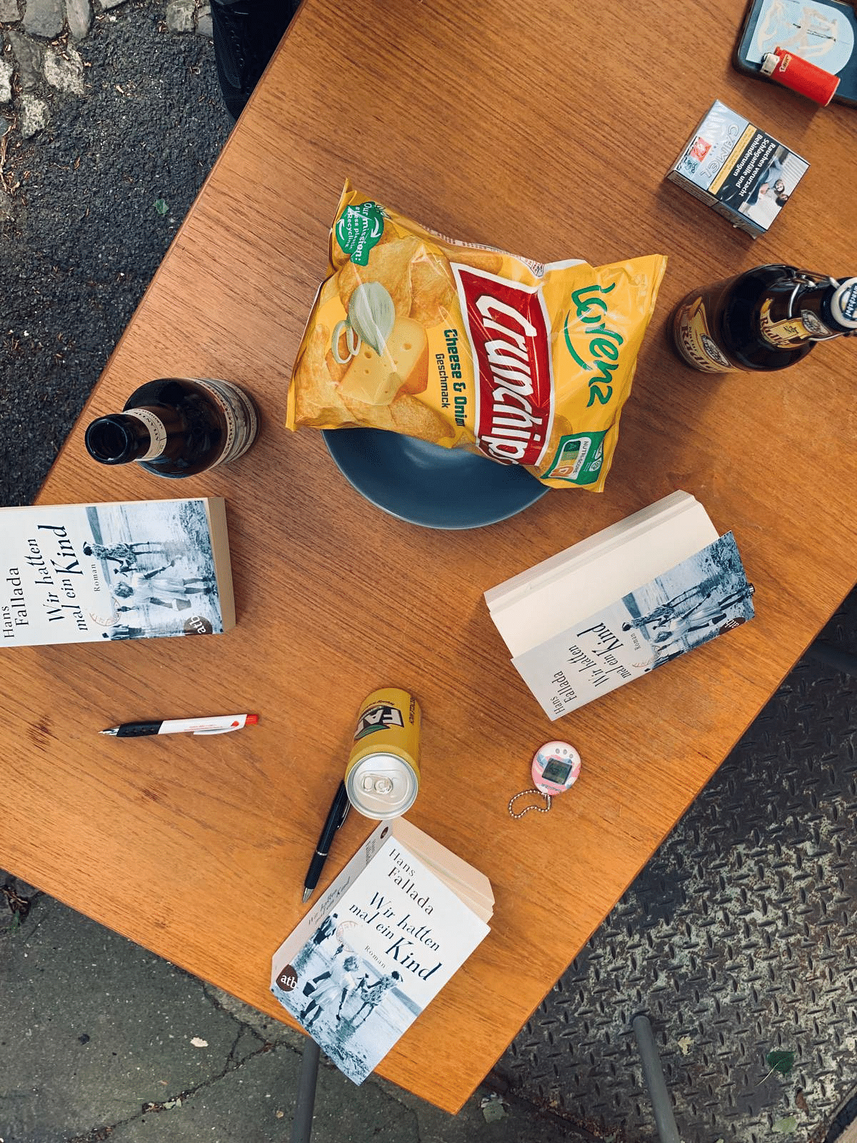 Holztisch mit Büchern darauf, Chips und Getränken