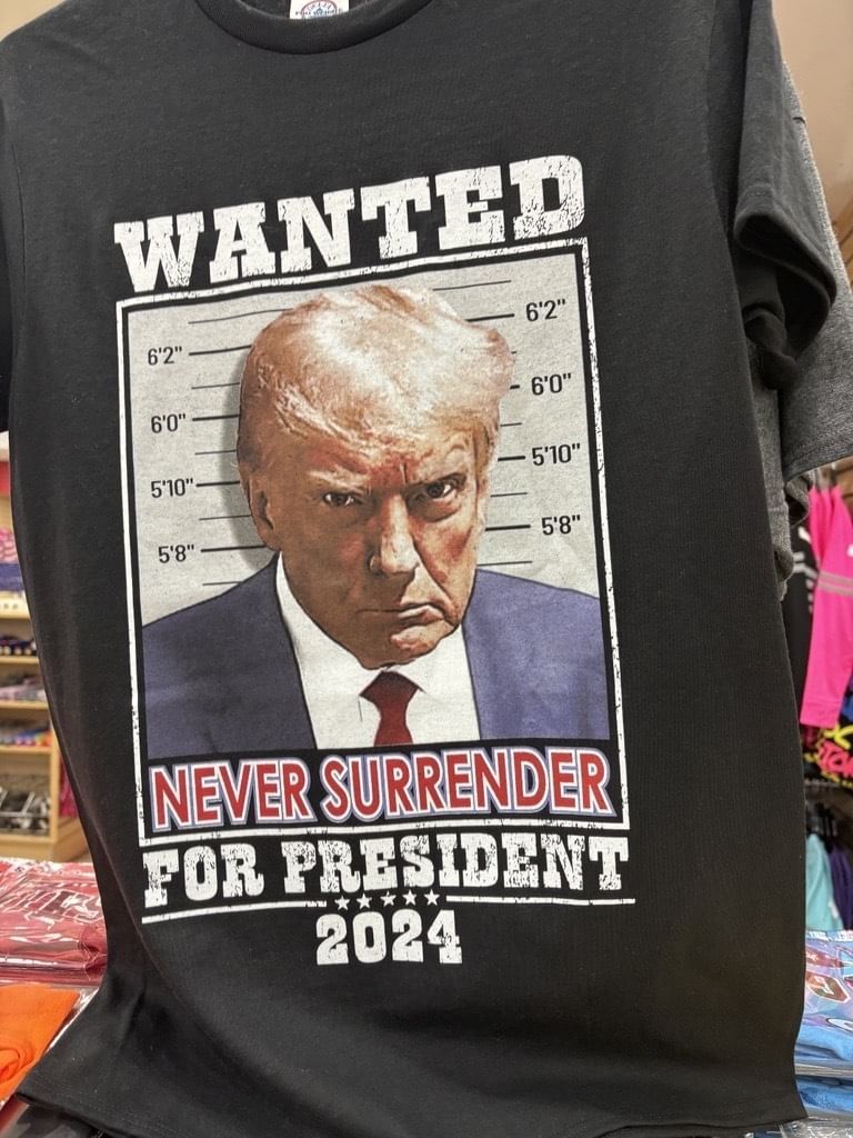 schwazes T-shirt mit Trump-Mugshot und Überschrift: WANTED NEVER SURRENDER FOR PRESIDENT 2024