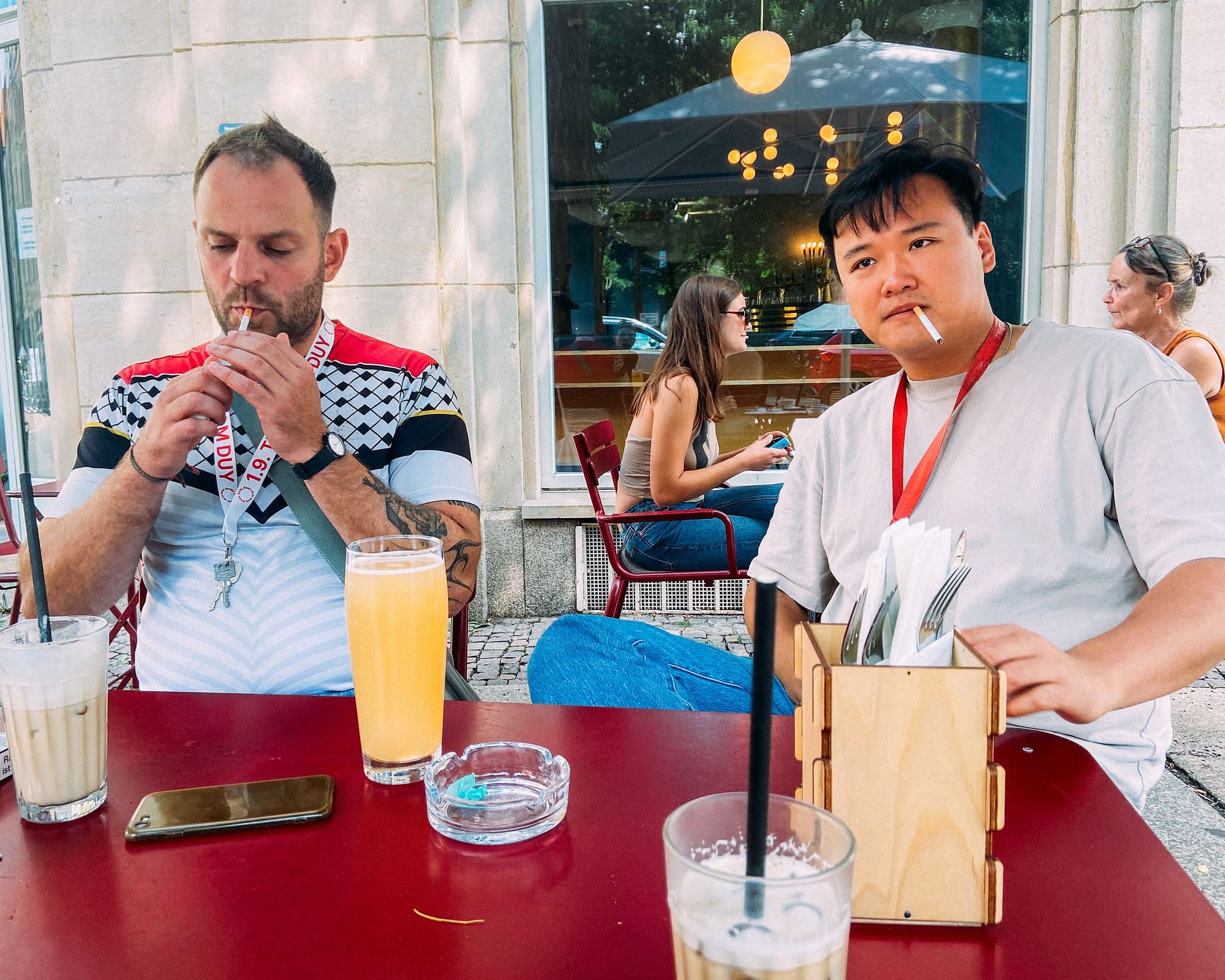 Nam Duy Nguyen und ein Kollege sitzen rauchend im Café.