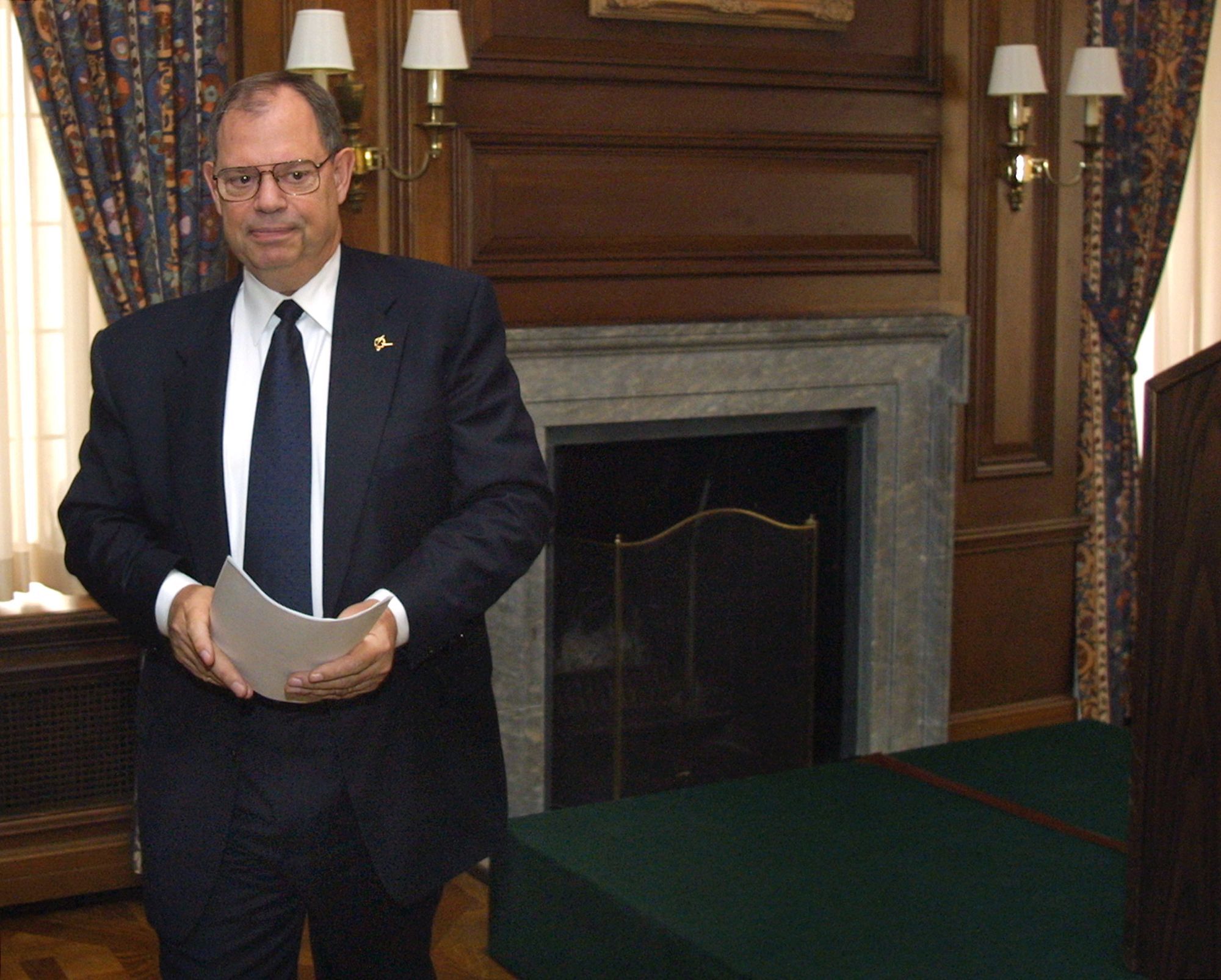 Phil Condit mit einem Stapel Papier in der Hand. Er trägt einen Anzug.
