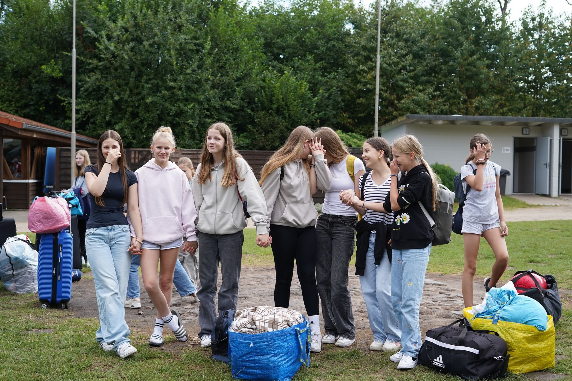 Gruppe Mädchen, halten Händchen, stecken die Köpfe zusammen.