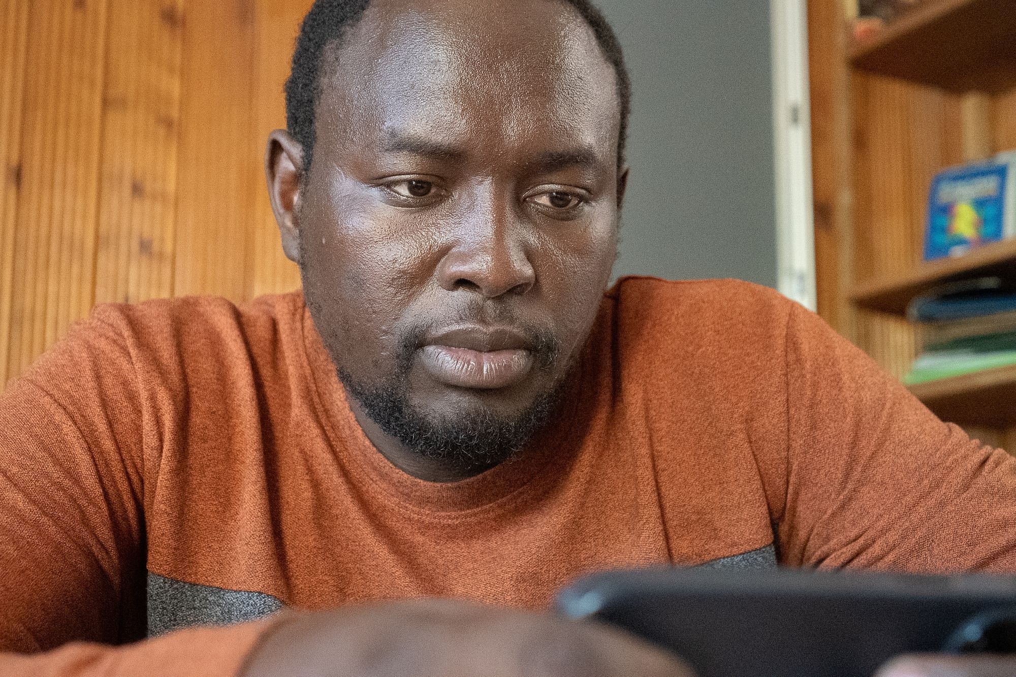 Der Anwalt Joseph Oleshangay blickt auf sein Handy.
