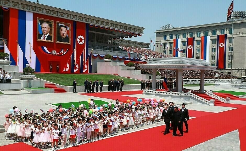 Putin und Kim Jong-un spazieren vor martialischer Kulisse.