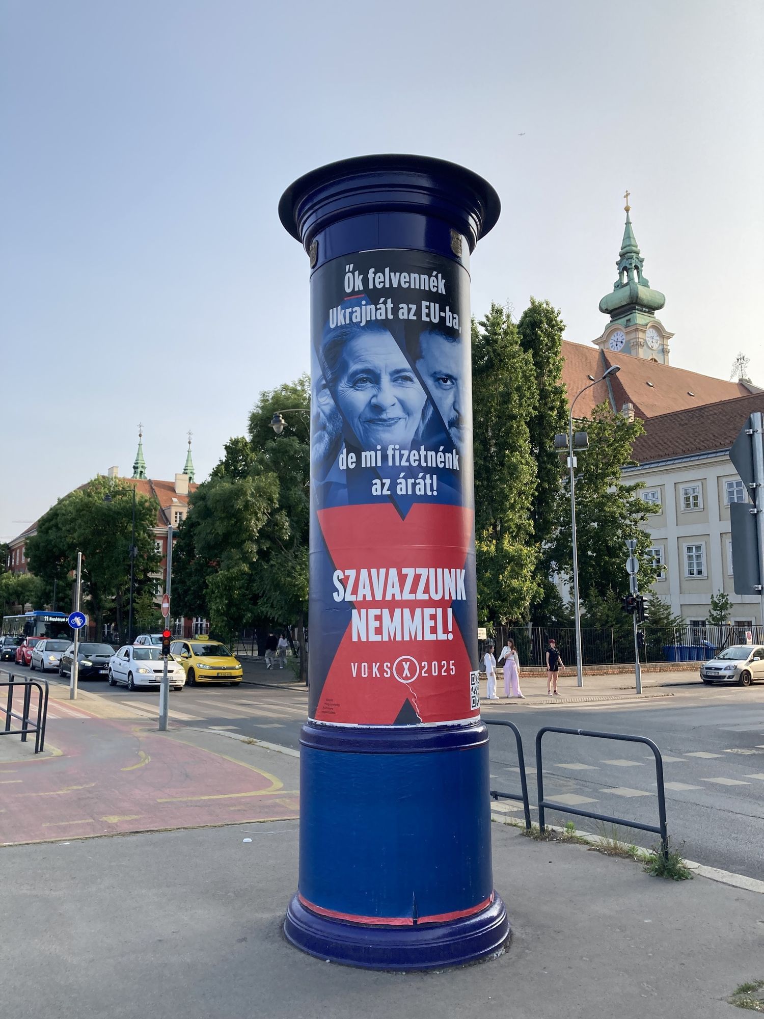 Auf dem Foto ist eine Littfaßsäule, darauf ist ein Plakat mit den Gesichert von Manfred Weber, Ursula von der Leyen und Wolodymyr Selenskyj, die sehr grimmig schauen.