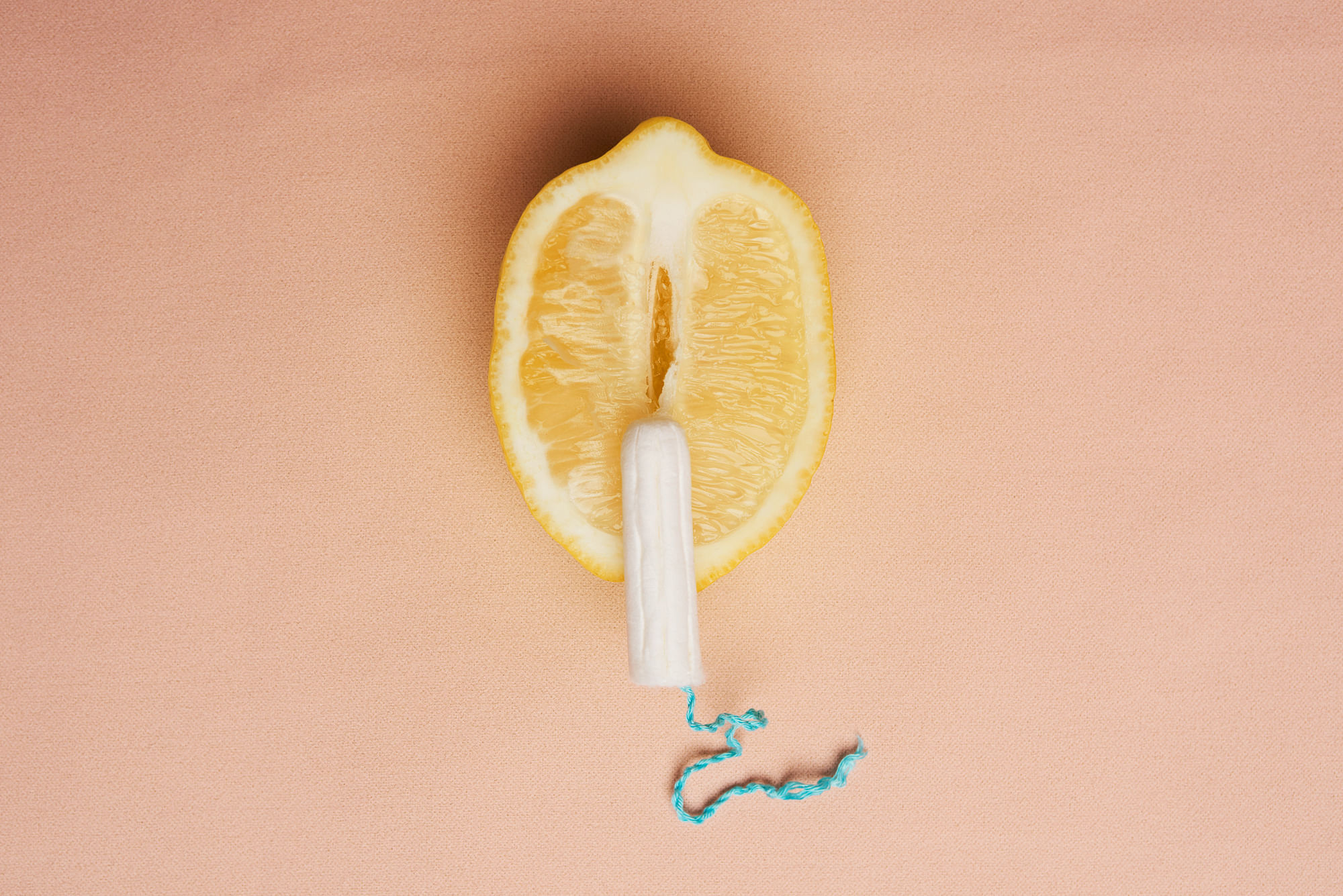 Eine halbierte Zitrone, auf der ein Tampon liegt