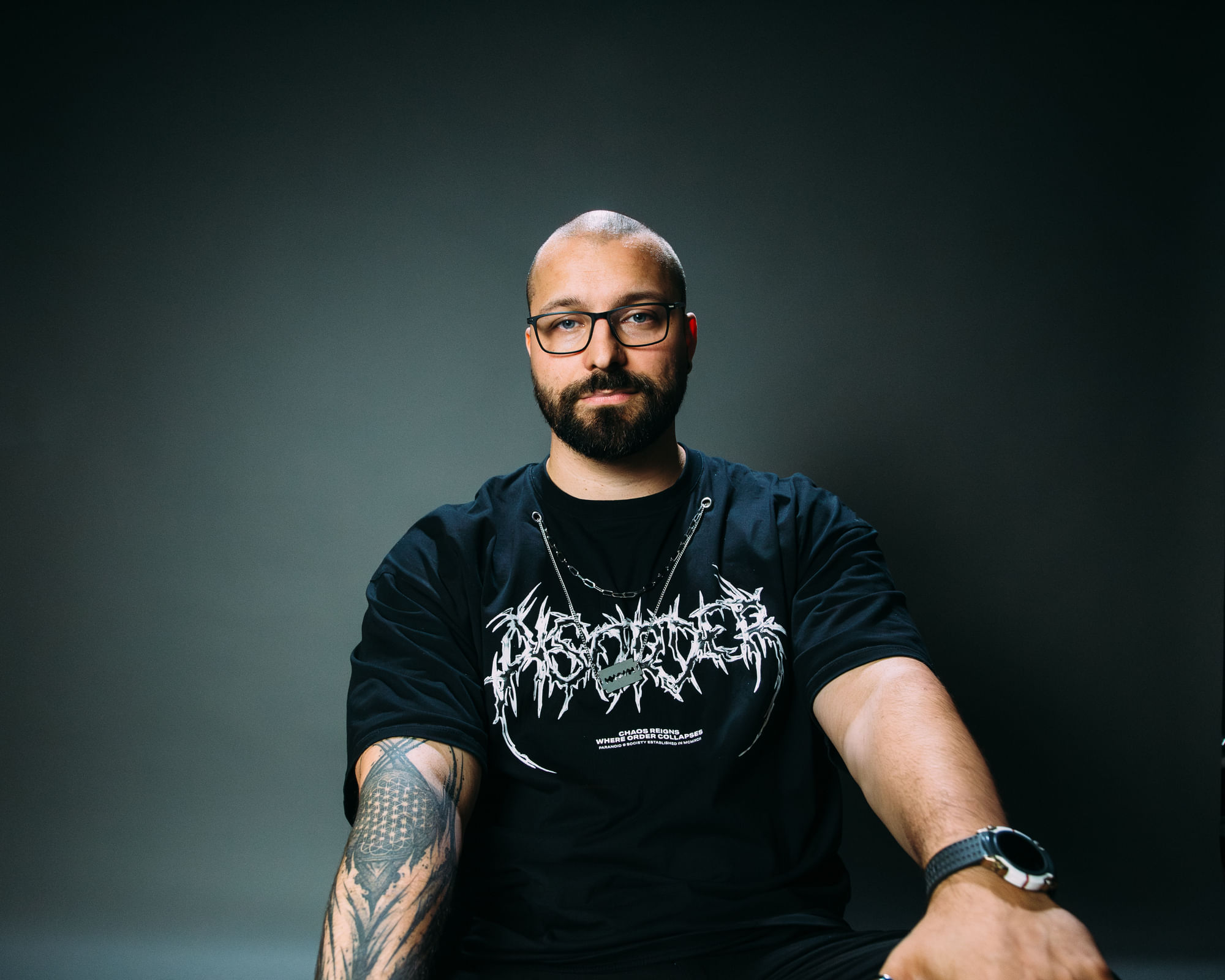Ein Portraitbild von Tristan Härter. Er schaut in die Kamera, im Hintergrund eine dunkelgrün-graue Fläche.