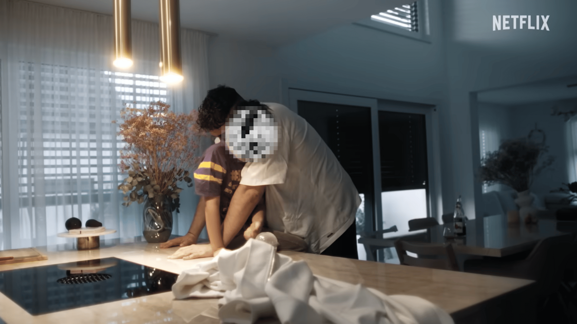 Screenshot aus der Doku: Haftbefehl umarmt seinen Sohn am Küchentisch.