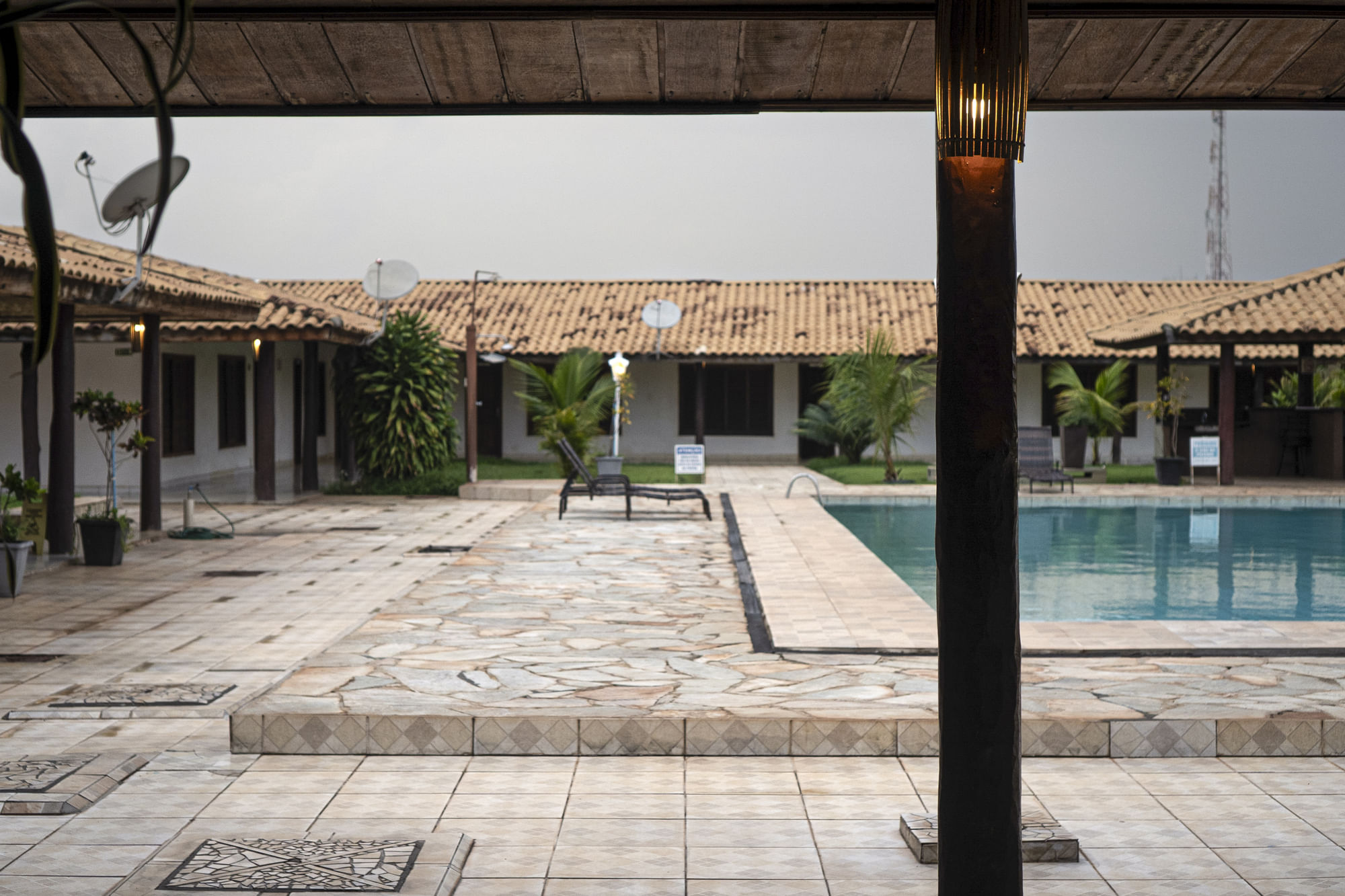 Ein Swimming-Pool liegt in der Mitte eines flachen Hotel-Innenhofs.