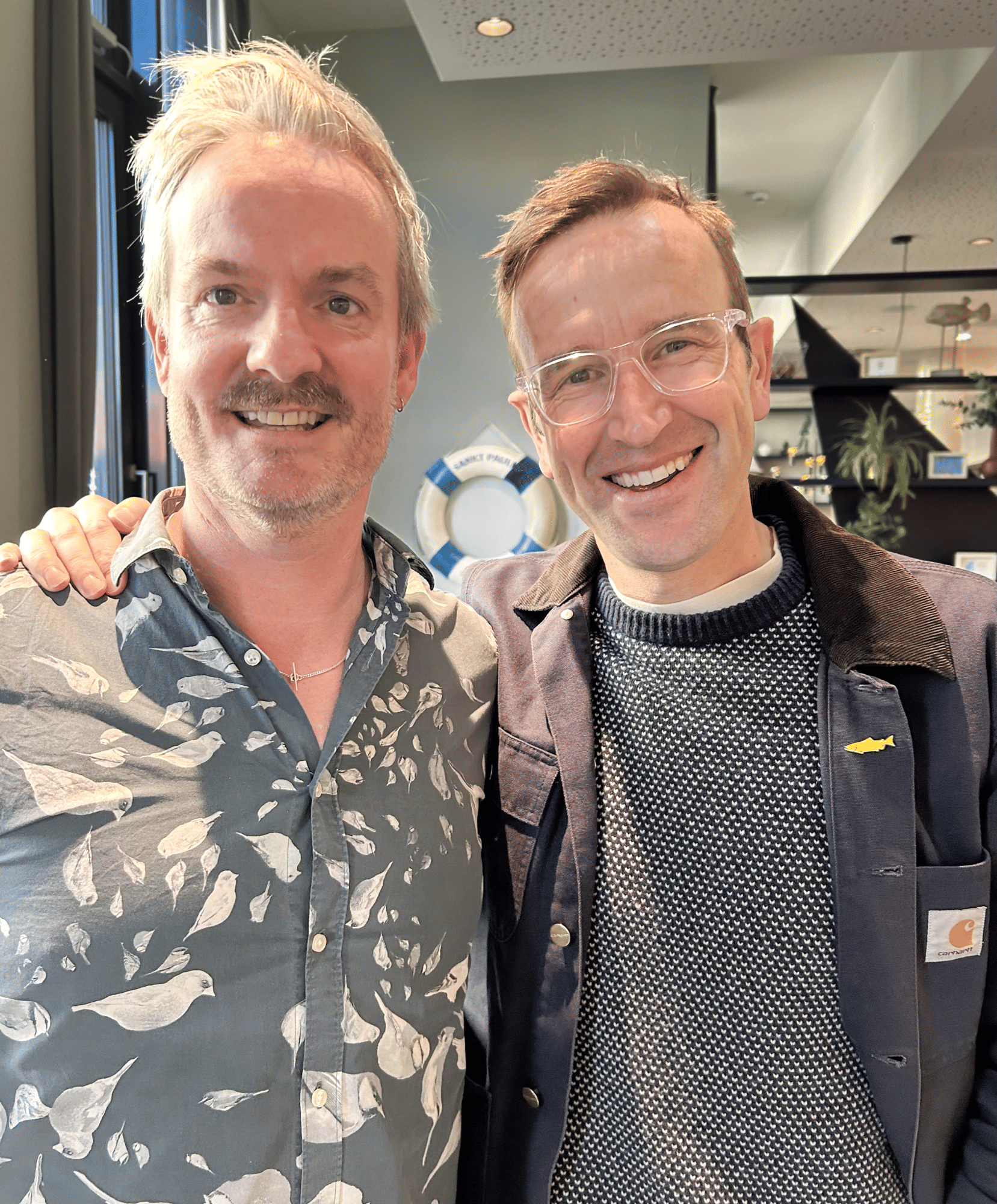 Roland Rödermund (links) trifft Robert Macfarlane in Hamburg. Er trägt ein Hemd mit Kohlmeisen-Muster.